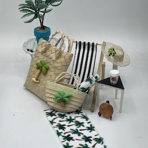 May include: A miniature beach scene with a woven tote bag, a small straw bag, a beach chair, a sun hat, and a palm tree. A small rug with palm tree designs is in the foreground. A small table holds a coffee cup. A miniature palm tree is in a blue pot.