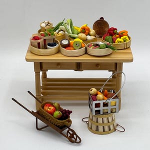 May include: Miniature wooden table with various baskets of produce, including berries, mushrooms, and peppers. A small wheelbarrow filled with fruit and a basket of vegetables are also present. The scene is set against a white background.