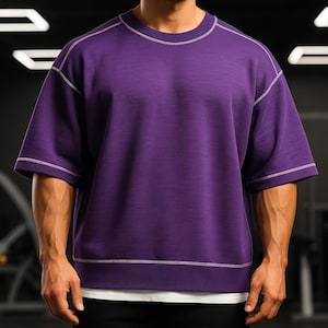 Pode incluir: Uma camisa de manga curta roxa com costuras brancas ao redor do pescoço e das mangas.