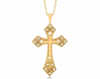 May include: A gold-colored pendant necklace featuring a cross design. The cross is adorned with small, clear gemstones set within decorative diamond-shaped patterns. The necklace has a delicate chain.