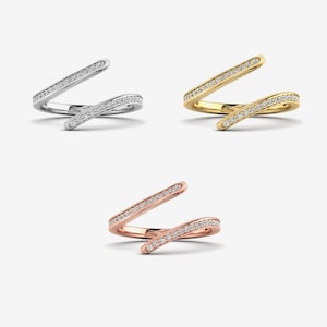 Pu&ograve; includere: Tre anelli in diverse finiture metalliche: argento, oro e oro rosa. Ogni anello presenta un design aperto unico con una fascia di piccole gemme scintillanti. Gli anelli sono esposti su uno sfondo bianco.
