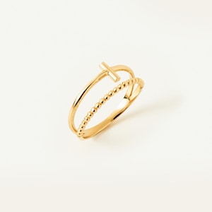 May include: A gold ring featuring a double band design. One band is a smooth, polished gold wire, while the other is a textured beaded band. The two bands are connected at the top by a small, horizontal gold bar, creating a cohesive piece.