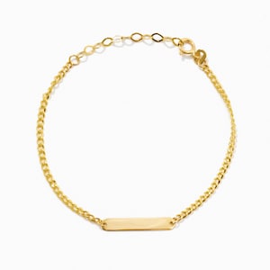 May include: A gold chain bracelet with a small, rectangular tag charm.
