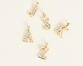 May include: Five gold-toned letter pendants featuring the letters J, S, A, K, and Z. Each pendant is crafted with a polished gold finish and inlaid with a vertical row of small, clear, round-cut stones along the center of each letter character.