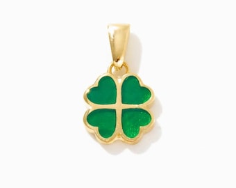 May include: A gold-toned pendant shaped like a four-leaf clover, featuring four heart-shaped sections filled with vibrant green enamel. The pendant includes a small, smooth gold-toned bail at the top for attachment to a chain or necklace.