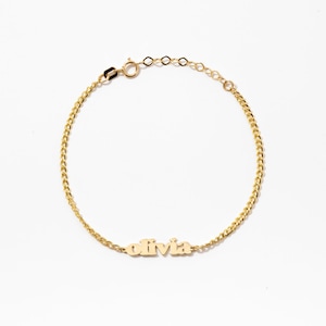 Könnte beinhalten: Ein goldfarbenes Kettenarmband mit einer zentralen Namensplatte, auf der der Name Olivia in einer stilisierten Schriftart steht. Das Armband besteht aus einer feinen Gliederkette und einem kleinen runden Verschluss mit einer Verlängerungskette.