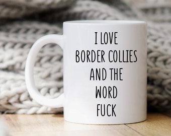 May include: White ceramic mug with the text "I LOVE BORDER COLLIES AND THE WORD FUCK" in black. The mug has a curved handle and is set against a neutral background.