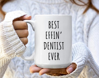 May include: White ceramic mug with black text that reads "Best Effin' Dentist Ever".