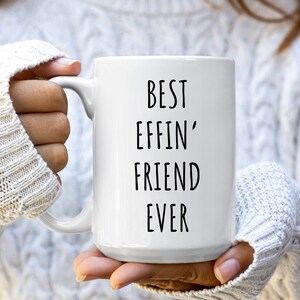 May include: White ceramic coffee mug with black text that reads "Best Effin' Friend Ever".