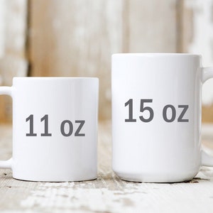 May include: Two white ceramic mugs with black text. The smaller mug is 11 oz and the larger mug is 15 oz.