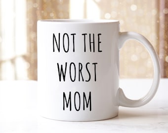 May include: White ceramic coffee mug with black text that reads "Not the Worst Mom".