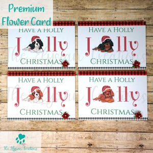 May include: Four Christmas cards featuring a Cavalier King Charles Spaniel wearing a Santa hat. Each card has a red and black checked background and the text "Have a Holly Jolly Christmas".
