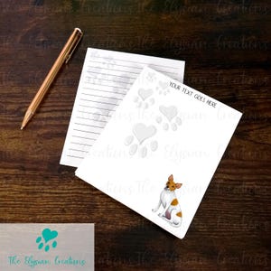 May include: White notepad with lined paper and a white dog paw print design. The dog is a Rat Terrier with brown and white markings. The text "YOUR TEXT GOES HERE" is printed on the notepad.