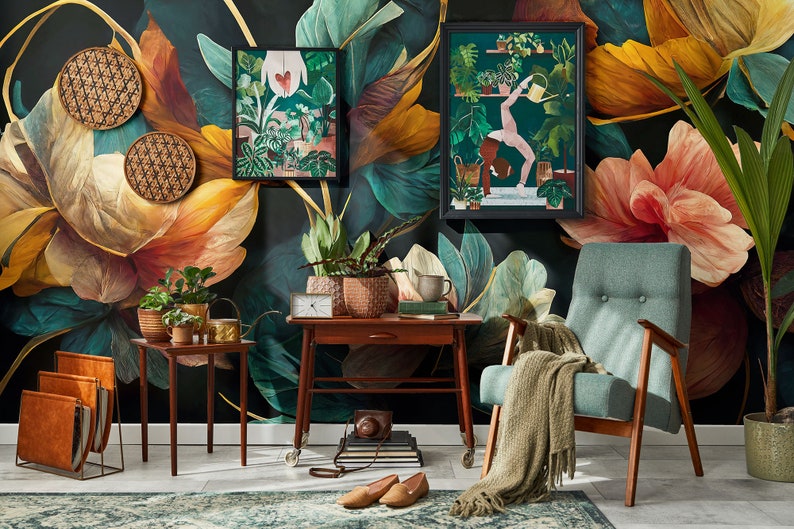 May include: A teal armchair with a green throw blanket sits in front of a dark green and gold floral wallpaper. Two framed botanical prints hang on the wall, one featuring a woman doing yoga and the other featuring a variety of plants. A wooden side table with a potted plant and books sits next to the chair.