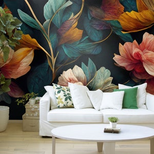May include: A white couch with pillows sits in front of a wall with a floral mural. The mural features large, colorful flowers in shades of red, orange, yellow, and green. The couch has a white throw blanket and a green pillow.