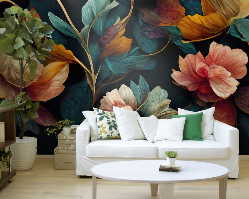 May include: A white couch with pillows sits in front of a wall with a floral mural. The mural features large, colorful flowers in shades of red, orange, yellow, and green. The couch has a white throw blanket and a green pillow.