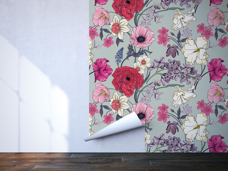 May include: A floral wallpaper with a green background and a variety of flowers in shades of pink, red, white, and purple. The wallpaper is being applied to a white wall.