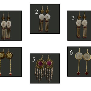 May include: A collection of six pairs of earrings. The earrings feature various designs, including white stone pendants with gold chains and red beads, and circular gold frames with red and white stones. Some have long chains with small beads.