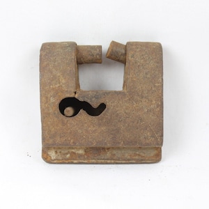 May include: A rusty metal padlock with a keyhole and a broken hasp. The padlock is square shaped and has a worn, aged appearance.