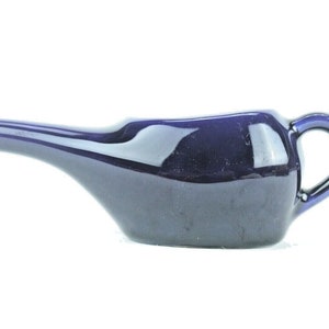 May include: A blue ceramic enema bulb with a spout and a handle.