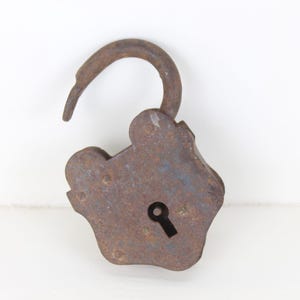 May include: A rusty metal padlock with a keyhole and a curved shackle. The padlock is open and the shackle is raised.