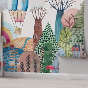 K&ouml;nnte beinhalten: Ein Aquarell-Wandbild mit einem Hei&szlig;luftballon, B&auml;umen und Blumen. Das Wandbild ist in einem verspielten Stil mit leuchtenden Farben und einem verspielten Design gemalt.