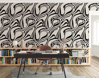 Op de afbeelding: Een thuiskantoor met een abstract behang in zwart-wit, een zwart bureau met een stoel en boekenkasten vol boeken.