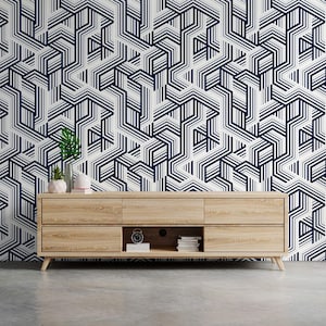 May include: A wooden media console with three drawers and a shelf. The console is in front of a wall with a geometric pattern of white and dark blue lines.