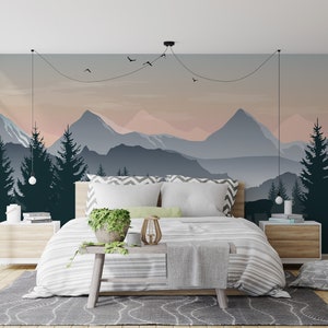 May include: A bedroom with a mountain range mural on the wall. The mural features a blue and pink sky with a silhouette of mountains and trees. A bed with white bedding and a green plant on a wooden stool is in the foreground.