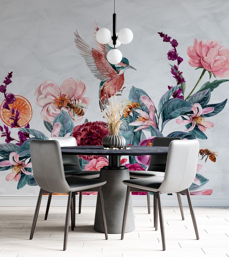 May include: A dining room set featuring a round black table and four gray chairs. The wall behind the table is adorned with a floral mural, including a hummingbird, bees, and various flowers in shades of pink, purple, and orange.