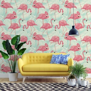 May include: A vibrant interior scene featuring a yellow sofa, potted plants, and a black and white patterned rug. The focal point is a wall covered in a repeating pattern of pink flamingos and tropical leaves on a light blue background.
