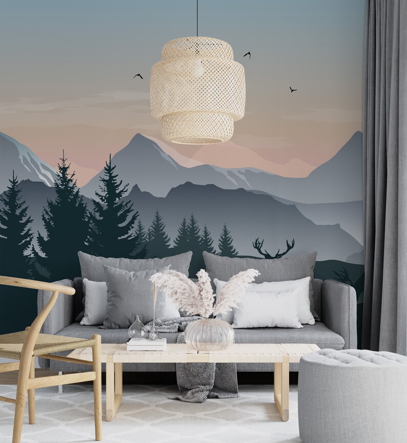 May include: A living room interior with a gray sofa and a wooden coffee table. The wall behind the sofa features a mountain landscape mural with a pink and blue sunset. A woven pendant light hangs from the ceiling.