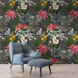 May include: A dark gray wallpaper with a floral pattern featuring white, pink, and blue flowers, green leaves, and yellow fruit. The wallpaper is accented with small blue birds. A blue armchair and ottoman are in the foreground.