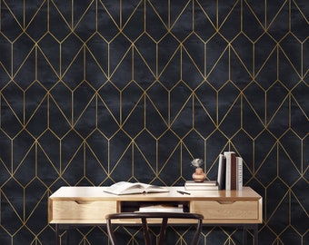 May include: A black and gold geometric wallpaper with a wooden desk and chair in front of it. The desk has two drawers and a book on top. There are also books on a shelf behind the desk.