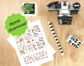 May include: Four printable digital bookmark designs with abstract patterns in shades of pink, orange, brown, and gray. The designs are printed on white paper and are arranged on a wooden surface. The text "digital download" is written on a green circle.