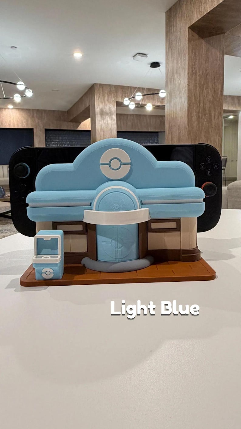 May include: A light blue and brown decorative building with a white accent, resembling a video game shop. The building has a light blue roof with a white circle design. The text "Light Blue" is visible on the surface.