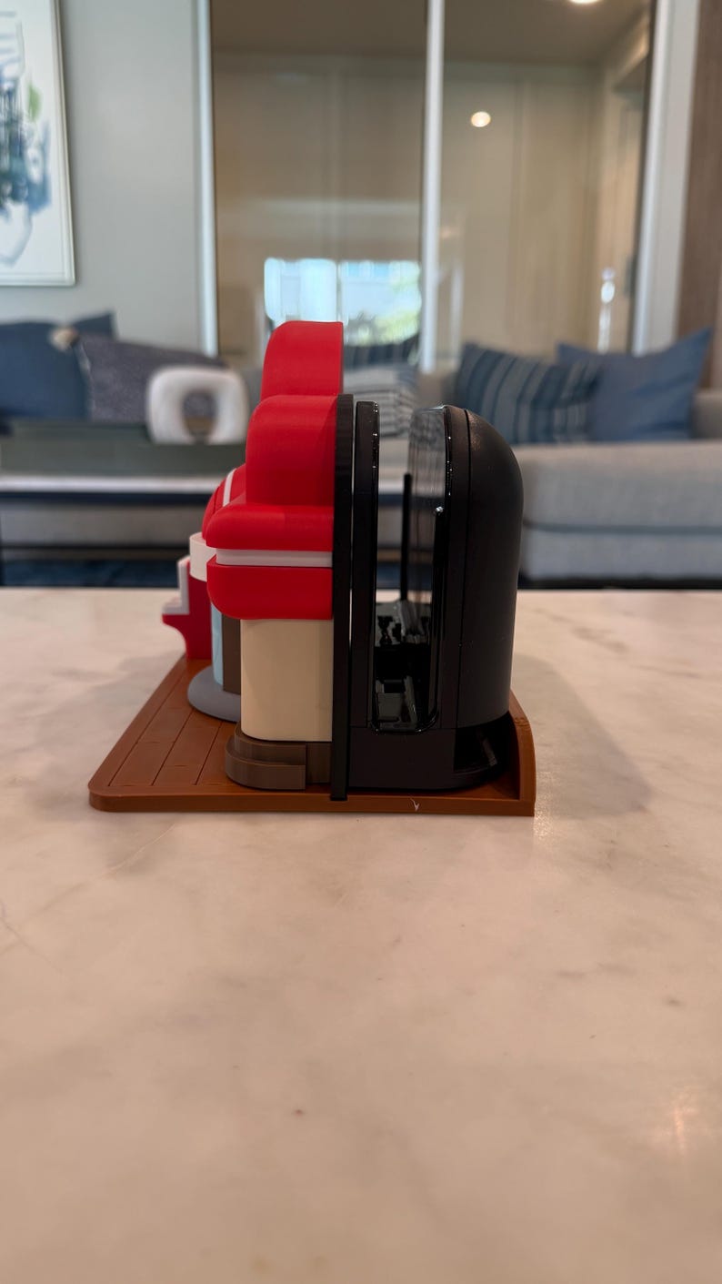 May include: A set of decorative bookends featuring a diner design. The bookends are red, white, and black, with a brown base. The bookends are made of plastic and are designed to hold books upright.