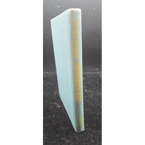 May include: A hardcover book with a light blue cover. The spine features gold lettering that reads "William Faulkner, The Unvanquished". The book is in good condition.