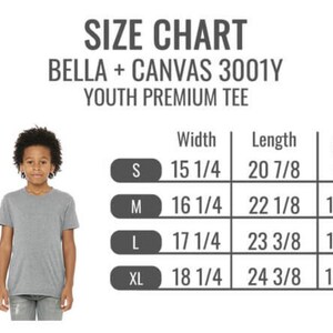May include: A young person wearing a gray t-shirt stands next to a size chart for Bella + Canvas 3001Y Youth Premium Tee shirts. The chart lists sizes S, M, L, and XL with width, length, and fit sizes. The text "SIZE CHART" is at the top.