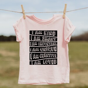 May include: Pink t-shirt with a black graphic that reads "I am kind, I am smart, I am important, I am unique, I am creative, I am loved."