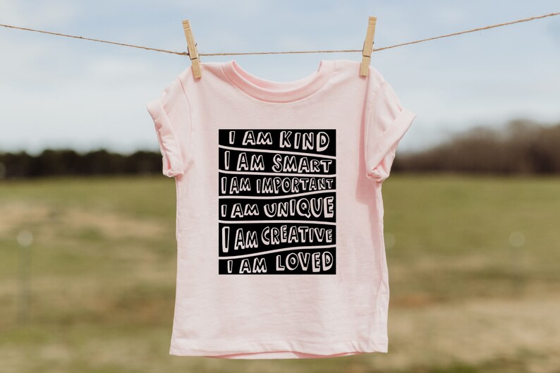 May include: Pink t-shirt with a black graphic that reads "I am kind, I am smart, I am important, I am unique, I am creative, I am loved."