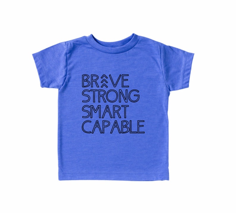 May include: A blue short-sleeved t-shirt with the words "BRAVE STRONG SMART CAPABLE" printed in black on the front.