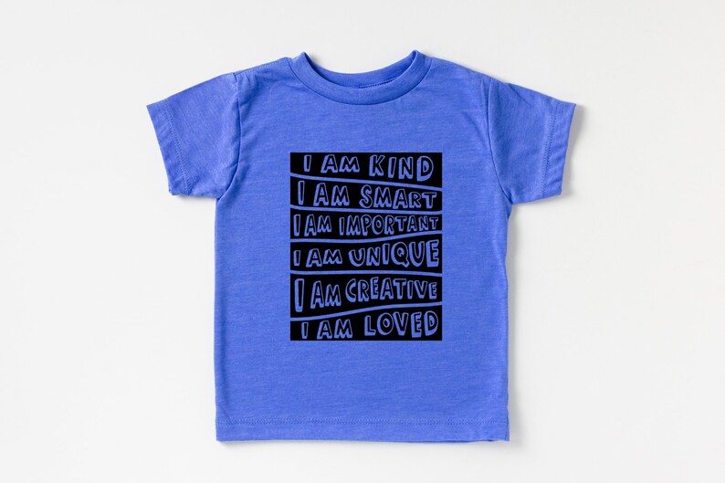 May include: A blue short-sleeved t-shirt with a black graphic that reads "I AM KIND, I AM SMART, I AM IMPORTANT, I AM UNIQUE, I AM CREATIVE, I AM LOVED".