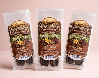 May include: Three clear plastic bags of vanilla beans. Each bag has a label with the text "Pennsylvanillabean" and "Vanilla Beans". The label also includes the text "Count: 10 Beans" and "Best Before 12/2030". The bags are on a pink background.
