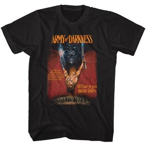 Pode incluir: Camiseta preta com uma estampa gráfica de uma cena do filme Army of Darkness. O gráfico mostra um homem segurando uma arma, uma caveira e o texto "What it gor was him."