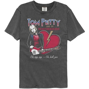 Op de afbeelding: Een zwart T-shirt met een vintage-stijl grafische afbeelding van Tom Petty and the Heartbreakers. De afbeelding bevat een rood hart met een bliksem, een gitaar en een portret van Tom Petty. De tekst "Tom Petty and the Heartbreakers" is gedrukt in blauwe en rode letters. De tekst "Oh, my, my - Oh, hell, yes" is gedrukt in zwarte letters.