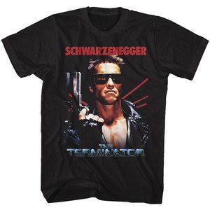 Könnte beinhalten: Schwarzes T-Shirt mit einem Grafik von Arnold Schwarzenegger aus Terminator. Das Design enthält den Text "SCHWARZENEGGER" in Rot und "THE TERMINATOR" in Blau sowie ein Bild von Schwarzenegger mit einer Waffe.