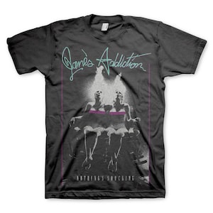 May include: A black t-shirt featuring a faded white graphic of two women seated on a throne. The text "Jane's Addiction" is written in a stylised font above the graphic. The text "Nothing's Shocking" is written below the graphic.
