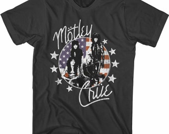 Puede incluir: Camiseta negra con un diseño de bandera estadounidense roja y blanca con la banda Motley Crue. Los miembros de la banda aparecen delante de la bandera. El nombre de la banda está escrito en blanco sobre la bandera y el logotipo de la banda está escrito en blanco debajo de la bandera.