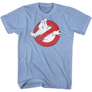 May include: A light blue t-shirt with a distressed red and white Ghostbusters logo. The logo features a ghost with a crossed-out circle.